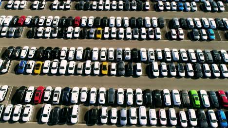 aerial footage of finished cars ready to be shipped on huge distribution center