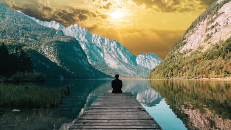 silueta, hombre, persona sentada frente al lago, montañas, hermosa naturaleza en el parque, efecto de reemplazo del cielo del atardecer cinematográfico, soledad, relajación