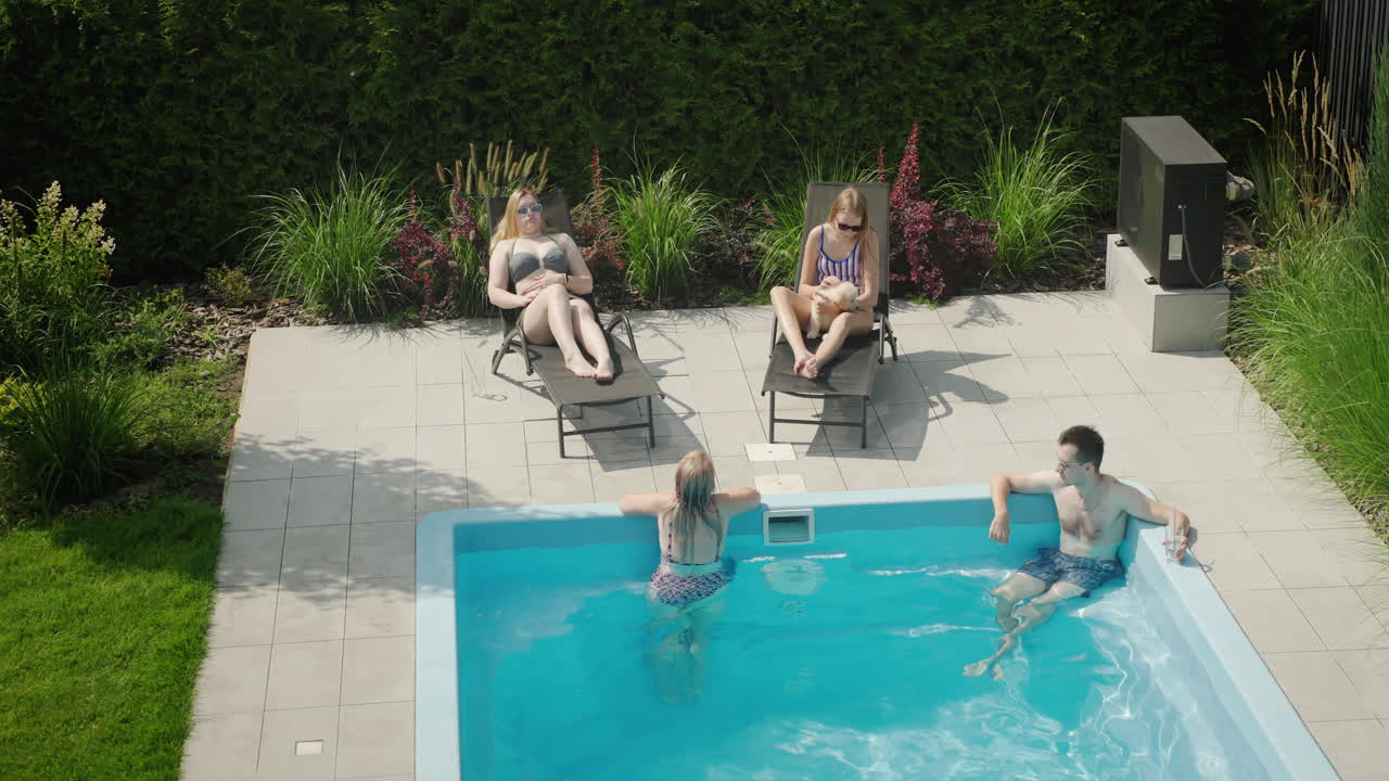 Familie med hund slapper af ved poolen
