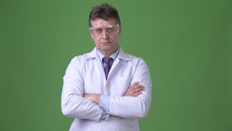 hombre maduro y guapo médico contra fondo verde