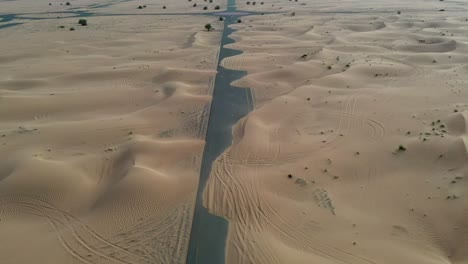 4k drone footage, a road between desert, dubai’s half desert road, geological landscape of high dune desert in the united arab emirates, drone videos