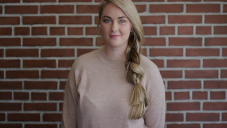 portrait attractive young blonde woman student smiling confident beautiful caucasian female on brick wall background slow motion