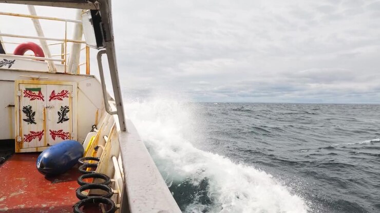 POV mentre si cammina sul ponte di un peschereccio in mare con mareggiata.