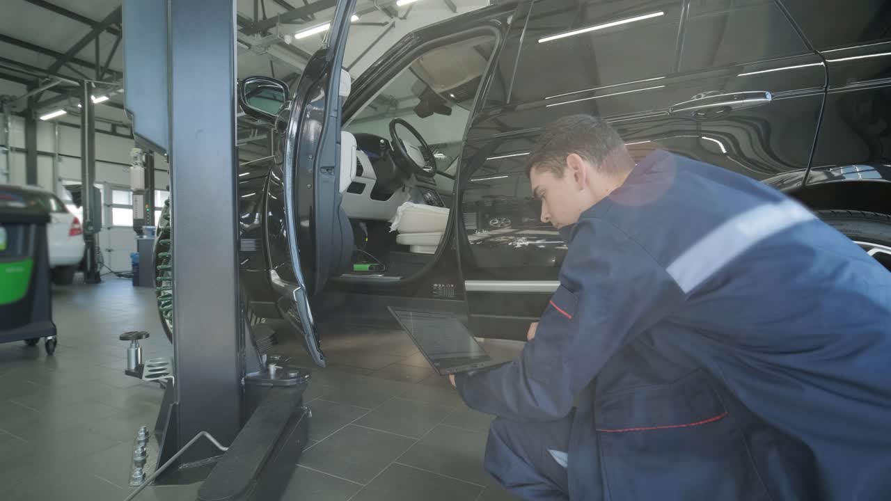 mecánico realizando diagnósticos de automóviles con una computadora portátil