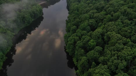 Reflejo-Del-Cielo-En-El-Agua-Del-Río-Rodeado-De-Un-Denso-Bosque,-Vista-Aérea