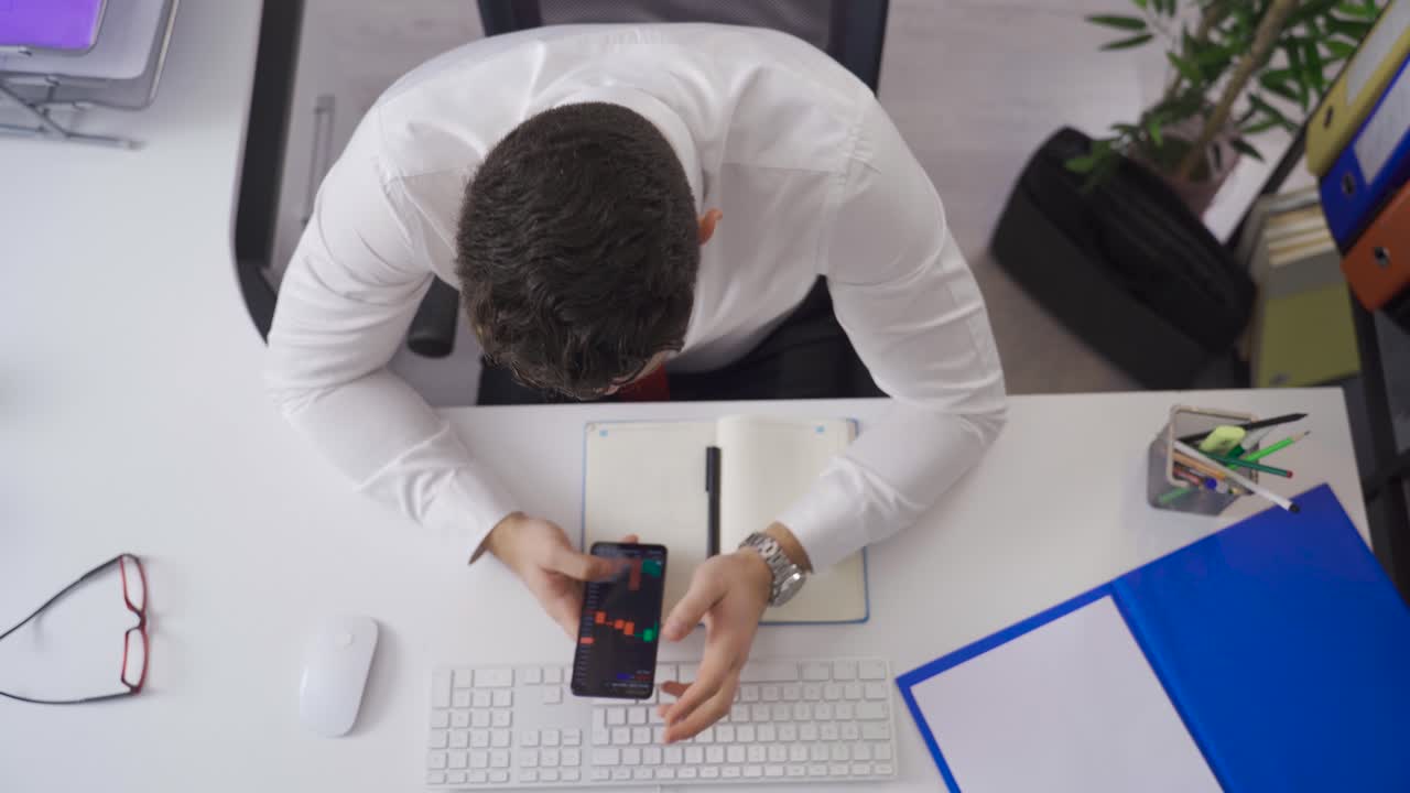 Stock trader businessman analyzing charts on his phone. Cryptocurrency and investment.