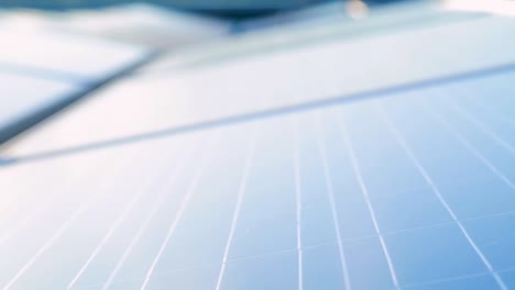 close-up panning shot of solar panels with selective focus and clear blue sky