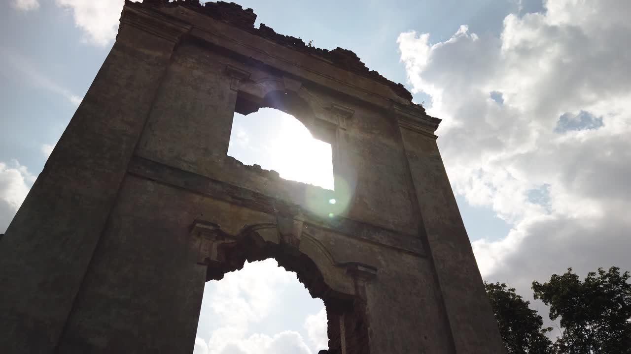 las ruinas del antiguo castillo histórico, la luz del sol atraviesa la ventana, árboles verdes alrededor, video de alta definición en cámara lenta