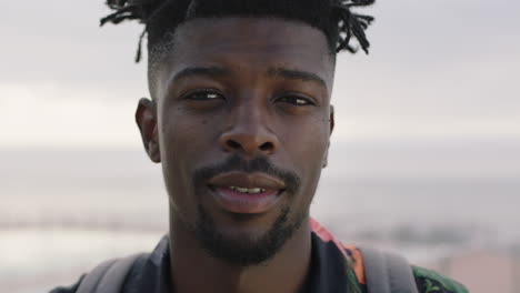 close up of attractive african american man removes sunglasses smiling confident