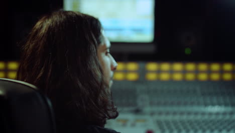 Compositor-Encendiendo-Una-Silla-En-El-Estudio.-Ingeniero-De-Sonido-Escuchando-Música-En-Interiores.