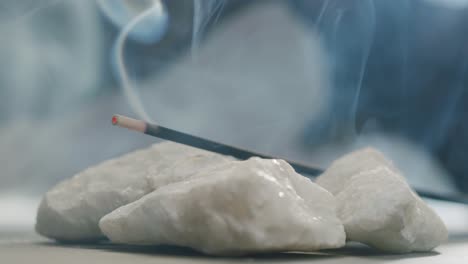 person holding palo santo wood stick in hand, aromatic palo santo burning on black background, smoke spreading around, slow motion video clip, high quality 4k close up footage. high quality 4k footage