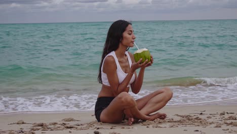 woman drinking coconut water on the beach