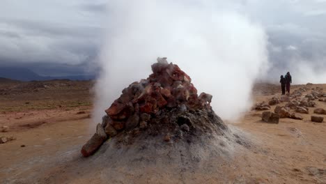 gran fumarola saliendo de las rocas muy rápidamente y sin pausa en la región geotérmica de námaskarð, en islandia