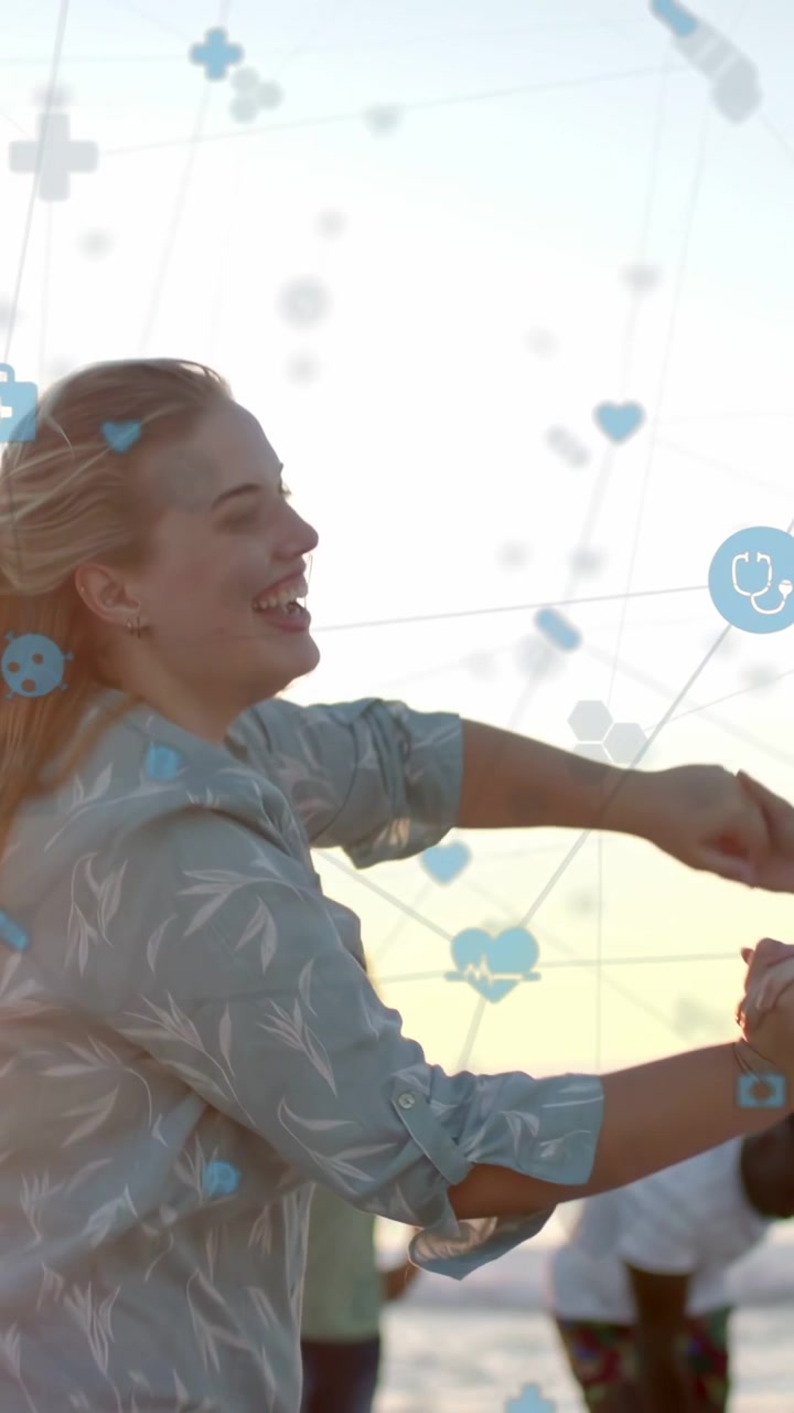 Video verticale: Donna che si tiene per mano, volteggiando giocosamente al tramonto mentre icone blu della salute fluttuano intorno.