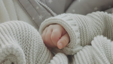 baby's hands in knitted sweater