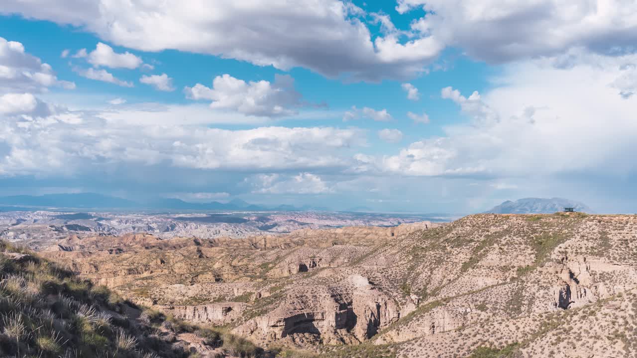 Moving clouds over desert cliffs in Gorafe landscape on sunny day