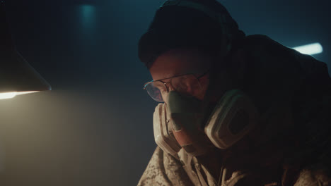 a bombmaker assembles a bomb in his workshop at night