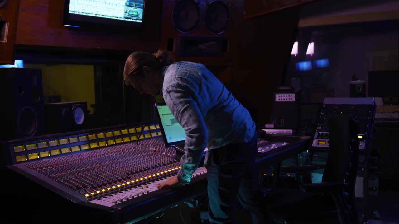 Male sound engineer working at a mixing desk