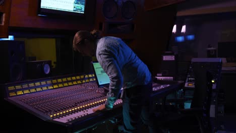 Male-sound-engineer-working-at-a-mixing-desk