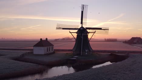 Drohnenansicht-Von-Babuurstermolen-Mit-Sonne-Hinter-Den-Rotorblättern-Bei-Sonnenaufgang,-Luftaufnahme