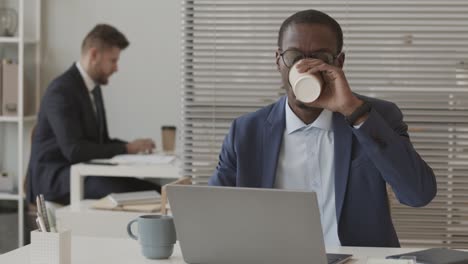 african american broker working on laptop in office