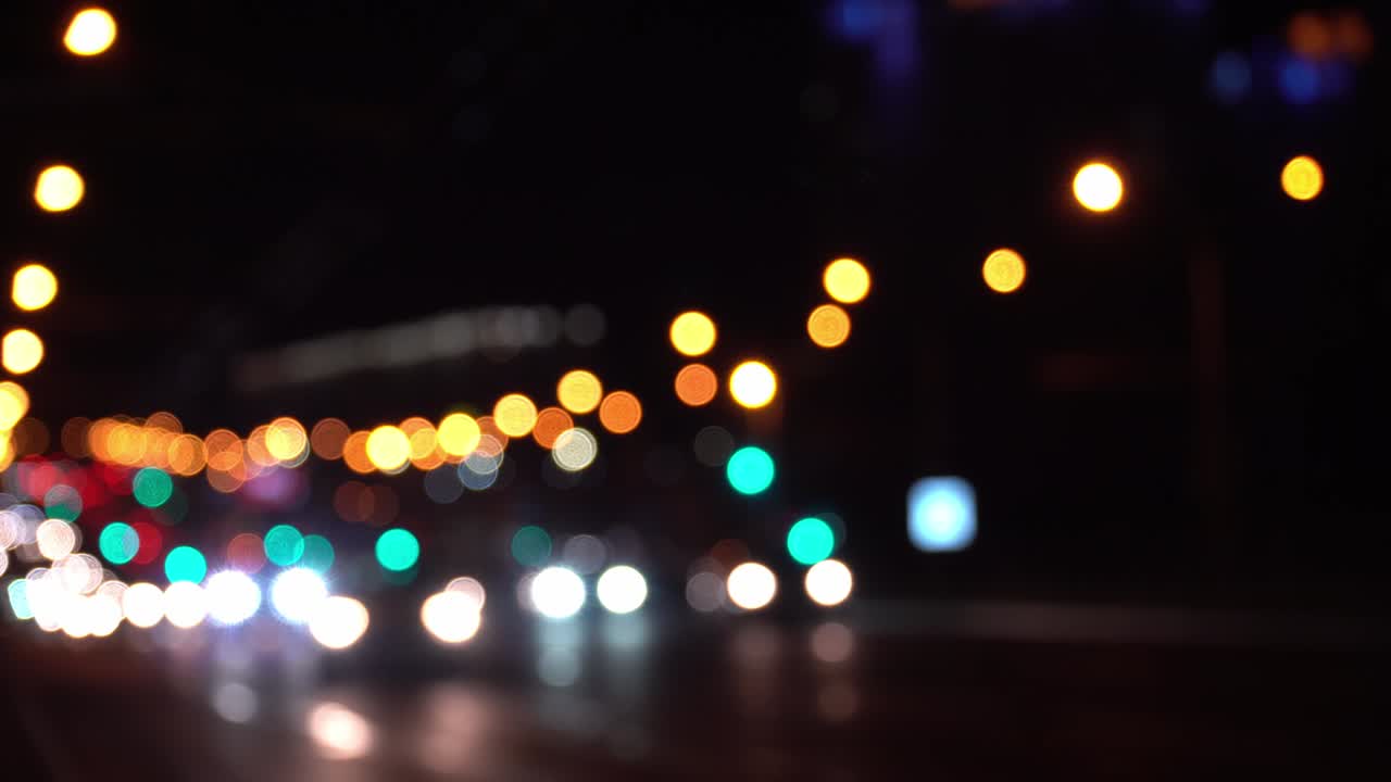 el colorido bokeh redondo brilla de las luces de los coches en el atasco de tráfico en la calle de la ciudad. hermoso bokeh brillante en el fondo oscuro borroso por la noche. concepto abstracto. refleja el estilo de vida solitario de la capital.