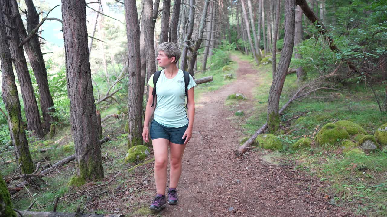 Frau wandert auf einem Pfad in einem Wald