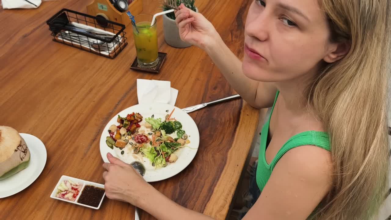 mujer comiendo ensalada en un restaurante
