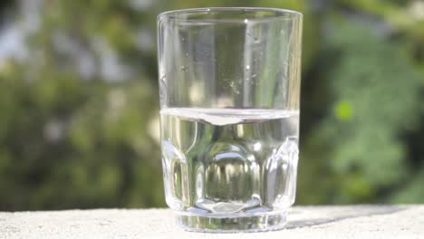 Glas,-Halb-Gefüllt-Mit-Wasser,-Das-In-Zeitlupe-Wirbelt