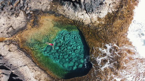 woman in pink swimsuit enjoys the turquoise waters of caleta de fuste