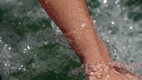 man's hand dragging in the water while skiing - close up