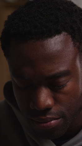 vertical video close up shot of unhappy and depressed young man sitting on sofa shaking head and shouting 1