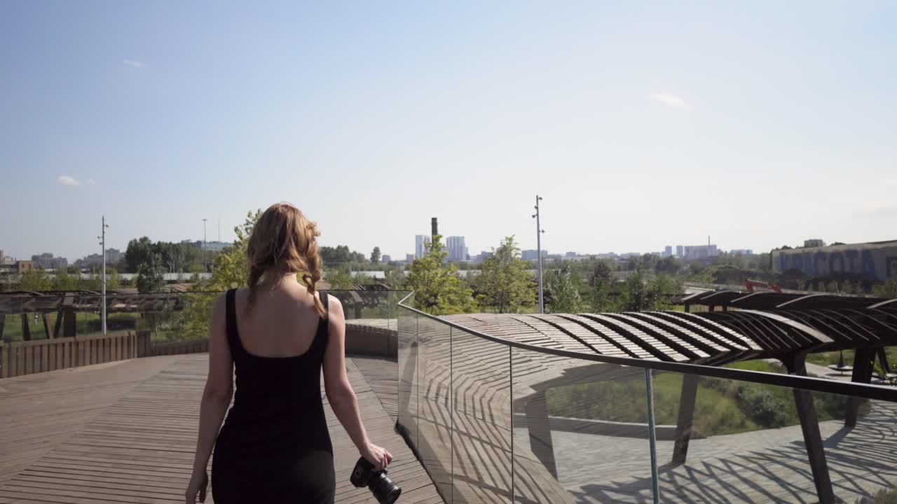 mujer caminando sobre un moderno puente de madera en un parque de la ciudad