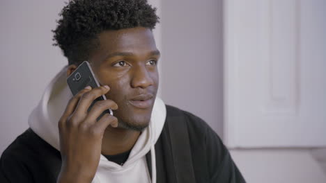 Portrait-of-smiling-young-man-talking-on-mobile-phone