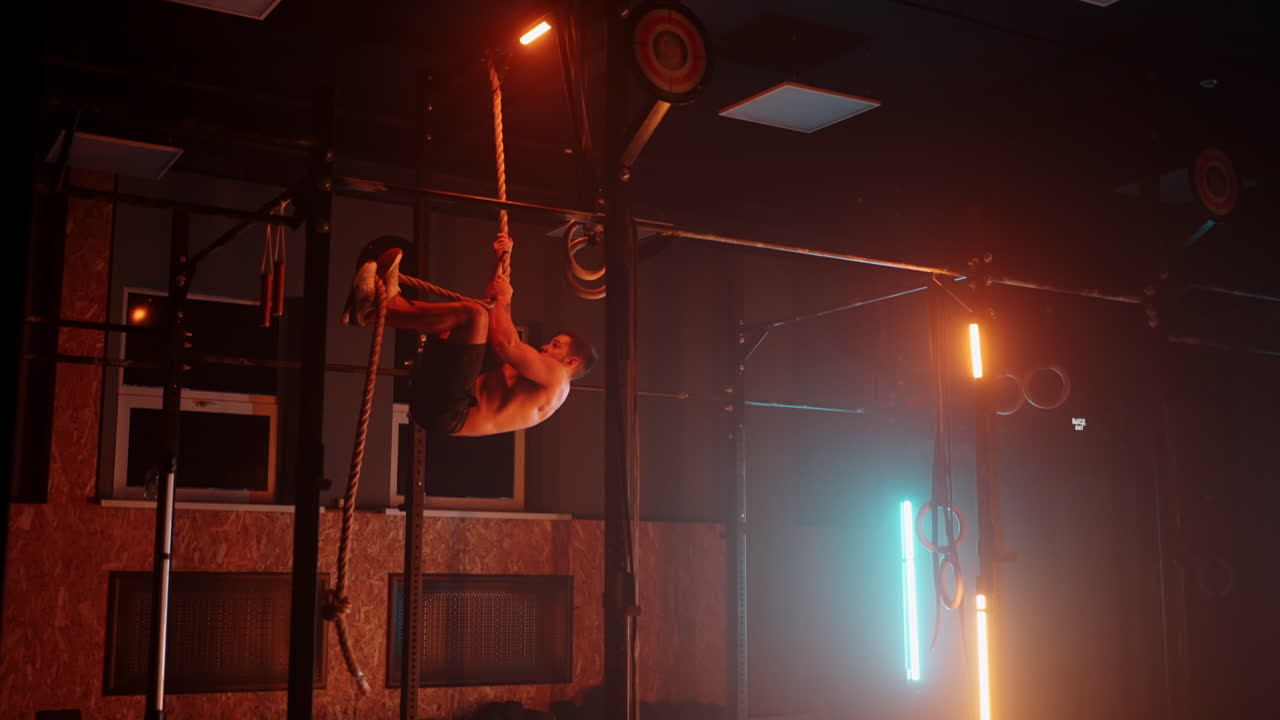 movimiento lento: hombre sano atleta cuerda de escalada entrenamiento entrenamiento intenso culturista muscular haciendo ejercicio de fuerza disfrutando del estilo de vida de fitness en el gimnasio vista superior.