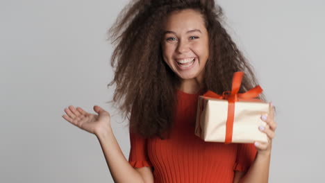 happy caucasian curly haired woman receiving a present.