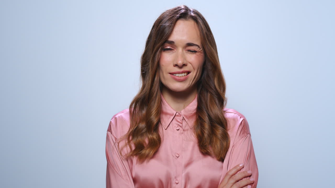 Donna pensierosa che riflette in studio. Seria donna d'affari che incrocia le mani.