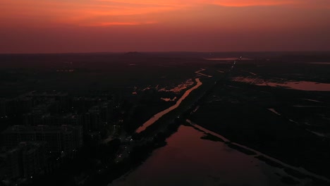 Fahrzeuge-Fahren-Nachts-Auf-Der-Straße-Mit-Rotem-Himmel-In-Vasai-Mumbai,-Indien