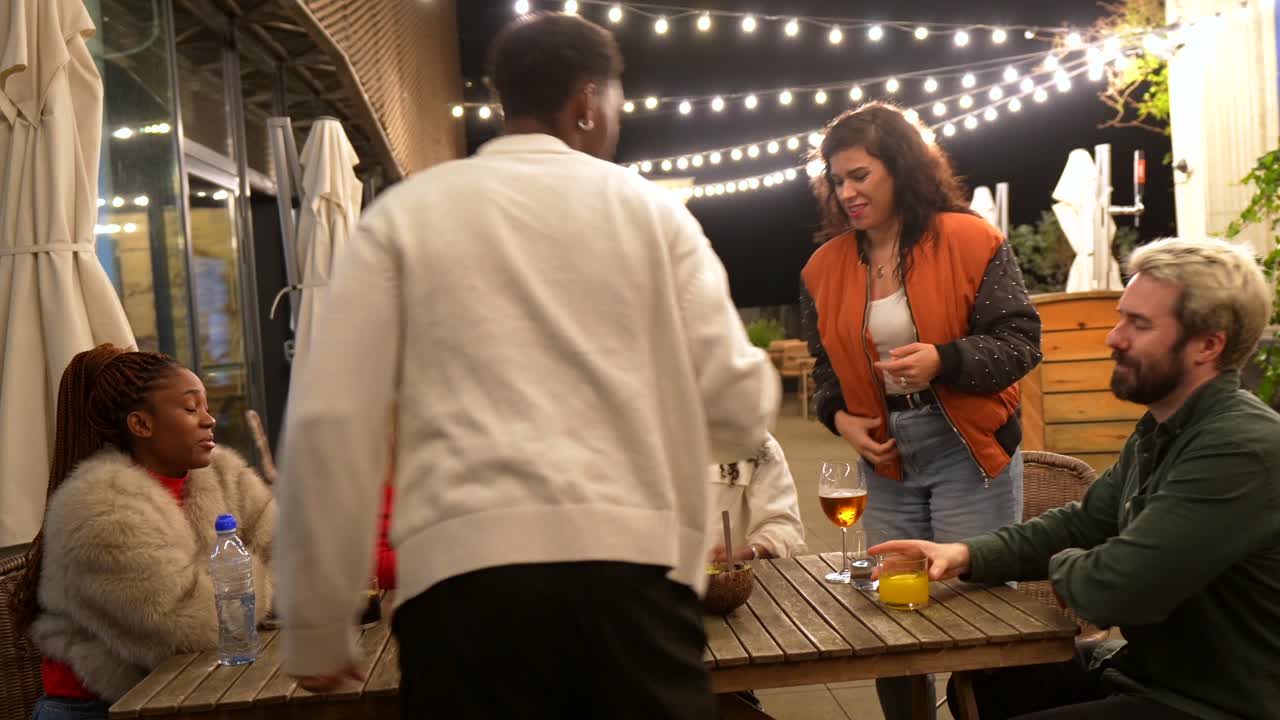 Friends enjoying a night out at an outdoor restaurant