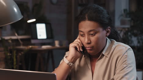 woman on a phone call in a dark office setting