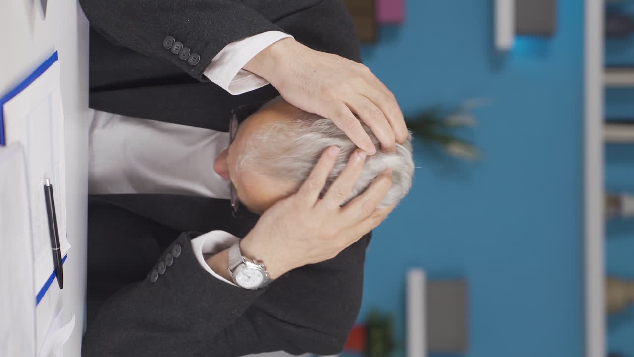 홈 오피스 직원 남자가 신경 ⁇ 약을  ⁇ 고 있는 수직 비디오.