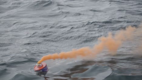 Una-Bengala-De-Humo-Naranja-Utilizada-En-Pruebas-De-Señales-De-Socorro-Flotando-En-El-Mar-Patagónico-Durante-El-Entrenamiento-Náutico---Toma-De-Primer-Plano