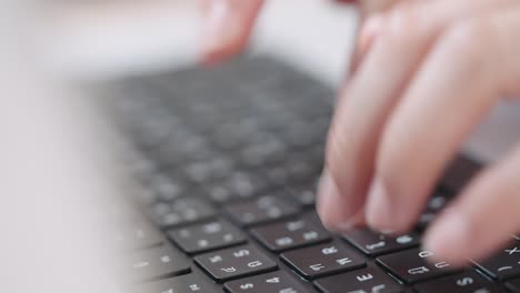 fotografía de cerca de las manos de una mujer de negocios escribiendo en el teclado de una computadora portátil para buscar información, soporte de comunicación en línea, investigación de mercadotecnia, informe de negocios en el escritorio de la oficina por la noche.