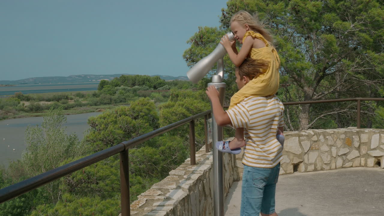 hermanos disfrutando de una vista panorámica a través de un telescopio