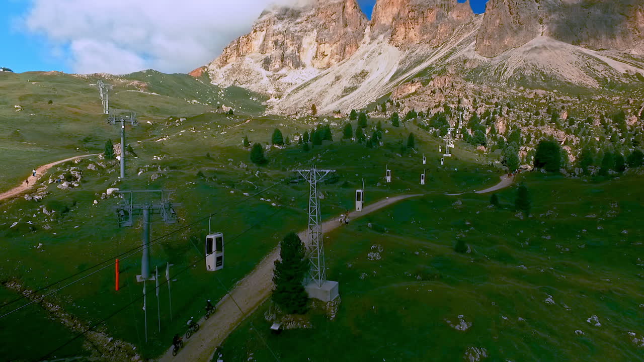 un grupo de diminutos ciclistas de montaña avanzan por un carril bici hacia la ciudad de piedra