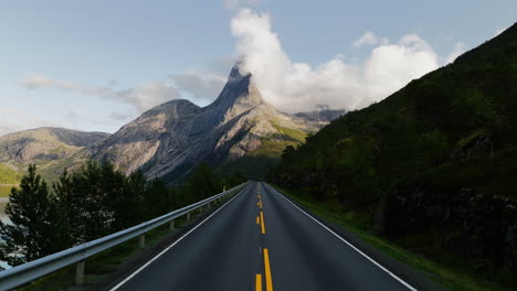 empty asphalt road leads to epic morning view of majestic stetind norway