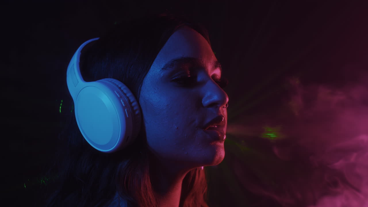 Asian Woman in Headphones Vaping in Nightclub