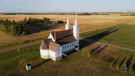 Aerial-shot-of-roman-catholic-church-in-north-American-prairie-during-sunset