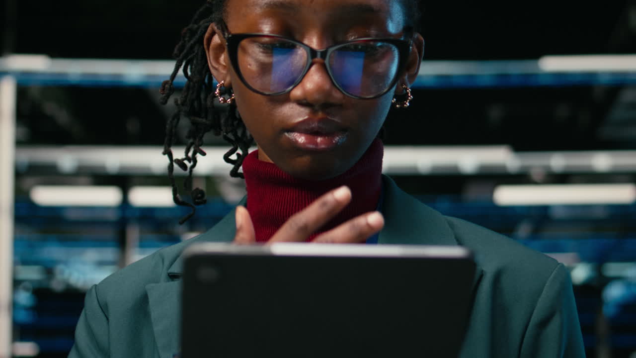 African American Woman Using Tablet and Smiling in Data Center