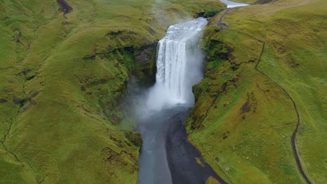 skogafoss waterfall on skoga river on south iceland in summer - aerial orbit drone footage. popular tourist attraction.